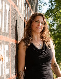 woman standing in front of wood wall