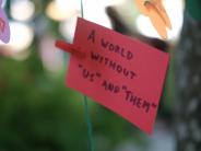 A sign reading "A world without us and them"